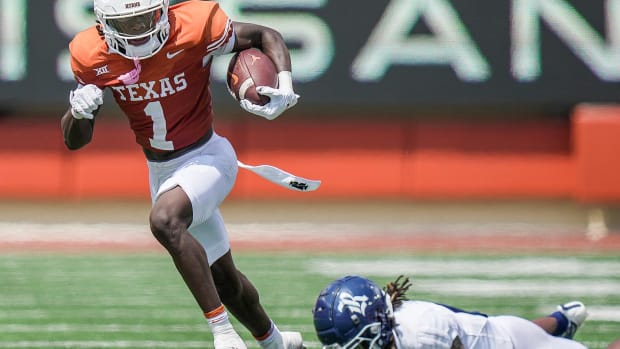 Texas Longhorns wide receiver Xavier Worthy (1) fights for yardage against Rice Owls cornerback Sean Fresch (1) in the first quarter of an NCAA college football game, Saturday, Sept. 2, 2023, in Austin, Texas.